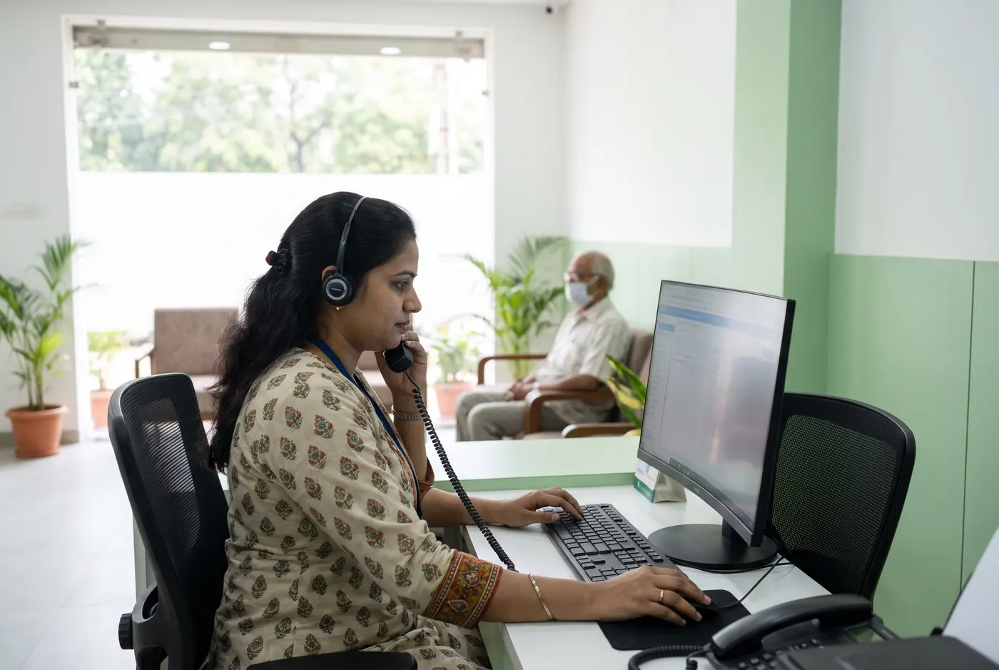 Clinic receptionist on a headset call at the front desk